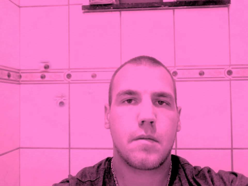 Kenneth kijkt recht in de camera, een selfie in een betegelde badkamer